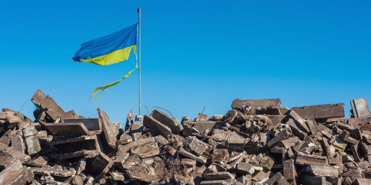 Ukraine flag over rubble.