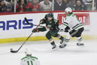 Minnesota Wild center Connor Dewar (26) handles the puck against Dallas Stars, defenseman Miro Heiskanen (4) during the first period of Game 4 of an NHL hockey Stanley Cup first-round playoff series Sunday, April 23, 2023, in St. Paul, Minn. (AP Photo/Stacy Bengs)