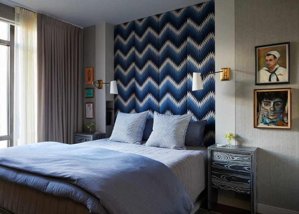 The master bedroom is a study of blues. The bed linens are by Thread Experiment, bedside tables from Aronson Woodworks, sconces by Roll & Hill, and the wallpaper is by Phillip Jeffries. All the art was found at a Chelsea flea market.