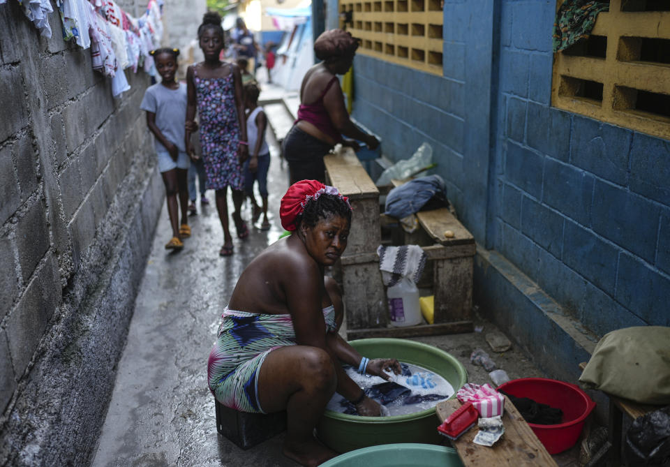 Baby Gustave washes clothes at a school converted into a shelter where she now lives after fleeing the gang violence in her neighborhood, in Port-au-Prince, Haiti, Saturday, May 18, 2024. On a Sunday afternoon in August 2023, Gustave fled home with her two daughters, taking only their birth certificates and her voting card. (AP Photo/Ramon Espinosa)