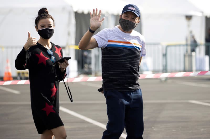 FILE PHOTO: FILE PHOTO: People gestures while exiting a Disneyland parking lot after receiving a dose of the Moderna COVID-19 vaccine at a mass vaccination site during the outbreak of the coronavirus disease (COVID-19), in Anaheim