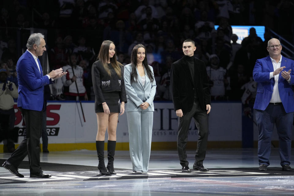 St. Louis Blues 2024 Hall of Fame Inductees Keith Tkachuk, right, and Mike Liut, left, join Maja Demitra, widow of fellow inductee Pavol Demitra, along with Demitra's son Lucas, second from right and daughter Zara, second from left, for a ceremonial puck drop before the start of and NHL hockey game against the Washington Capitals Saturday, Jan. 20, 2024, in St. Louis. (AP Photo/Jeff Roberson)