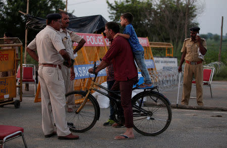 Police personnel stop a man from crossing a check point on a closed leading to Sunariya Jail in Rohtak in Haryana, India, August 27, 2017. REUTERS/Adnan Abidi