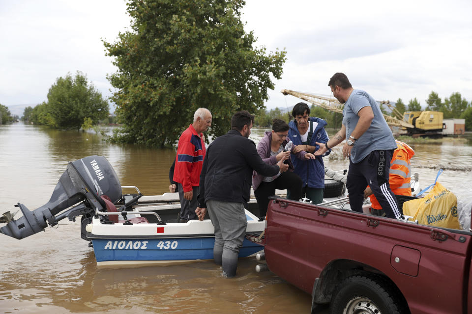 Local residents disembark from a small boat during an evacuee operation in the village of Farkadona, Thessaly region, central Greece, Thursday, Sept. 7, 2023. Greece's fire department says more than 800 people have been rescued over the past two days from floodwaters, after severe rainstorms turned streets into raging torrents, hurling cars into the sea and washing away roads. (AP Photo/Vaggelis Kousioras)