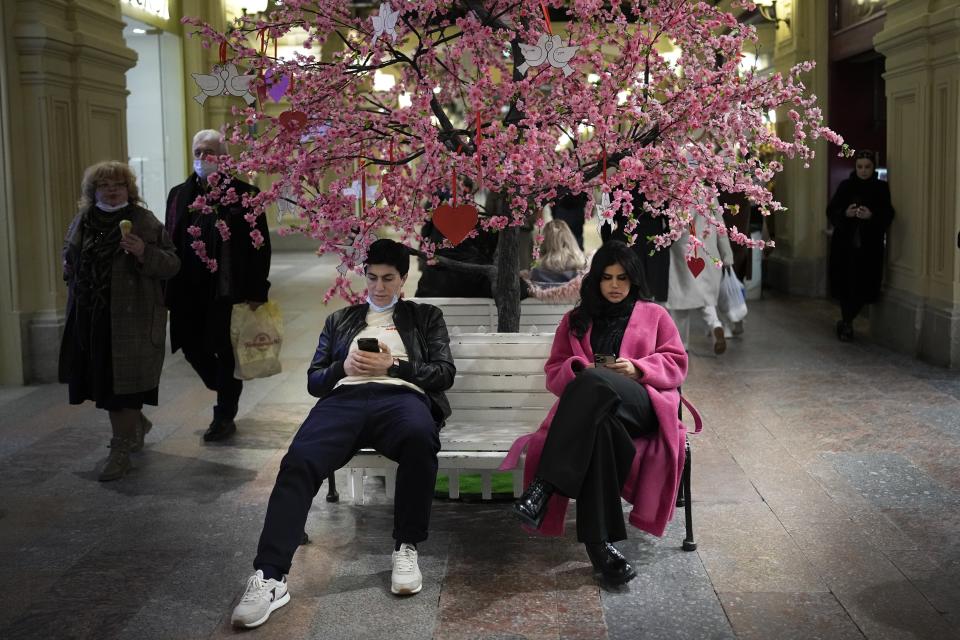 Visitors rest in the GUM department store in Moscow, Russia, Monday, Feb. 14, 2022. While the U.S. warns that Russia could invade Ukraine any day, the drumbeat of war is all but unheard in Moscow, where political experts and ordinary people alike don't expect President Vladimir Putin to launch an attack on the ex-Soviet neighbor. (AP Photo/Alexander Zemlianichenko)