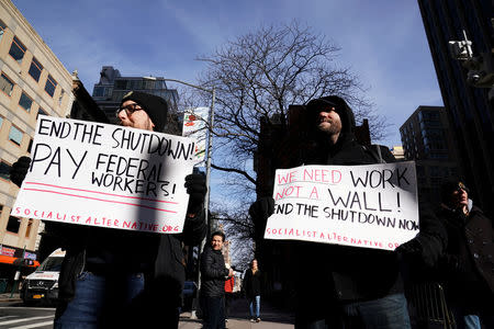 FILE PHOTO: Protesters hold signs during a rally outside a closed federal building in the Manhattan borough of New York City, New York, U.S., January 15, 2019. REUTERS/Carlo Allegri -/File Photo