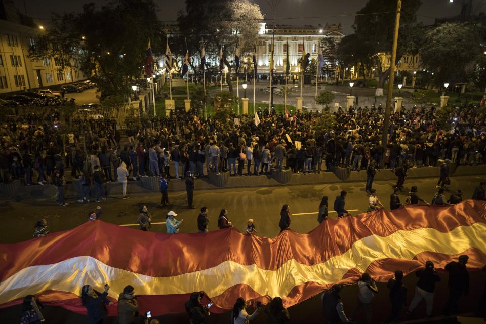 Demonstrators who had gathered to protest lawmakers pushing forward a vote to select an almost-full slate of new magistrates to the Constitutional Tribunal, continue outside Congress after President Martin Vizcarra dissolved the legislature in Lima, Peru, Monday, Sept. 30, 2019. Lawmakers were pushing forward the vote despite Vizcarra's warning that the move threatens his fight against corruption and that he would dissolve the opposition-controlled legislature. (AP Photo/Rodrigo Abd)