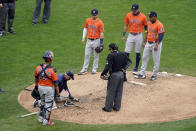 Houston Astros reliever pitcher Framber Valdez, right, waits as a grounds crew worker re-grooms an area of the mound before Valdez resumed pitching against the Minnesota Twins in the fifth inning in Game 1 of an American League wild-card baseball series, Tuesday Sept. 29, 2020, in Minneapolis. (AP Photo/Jim Mone)