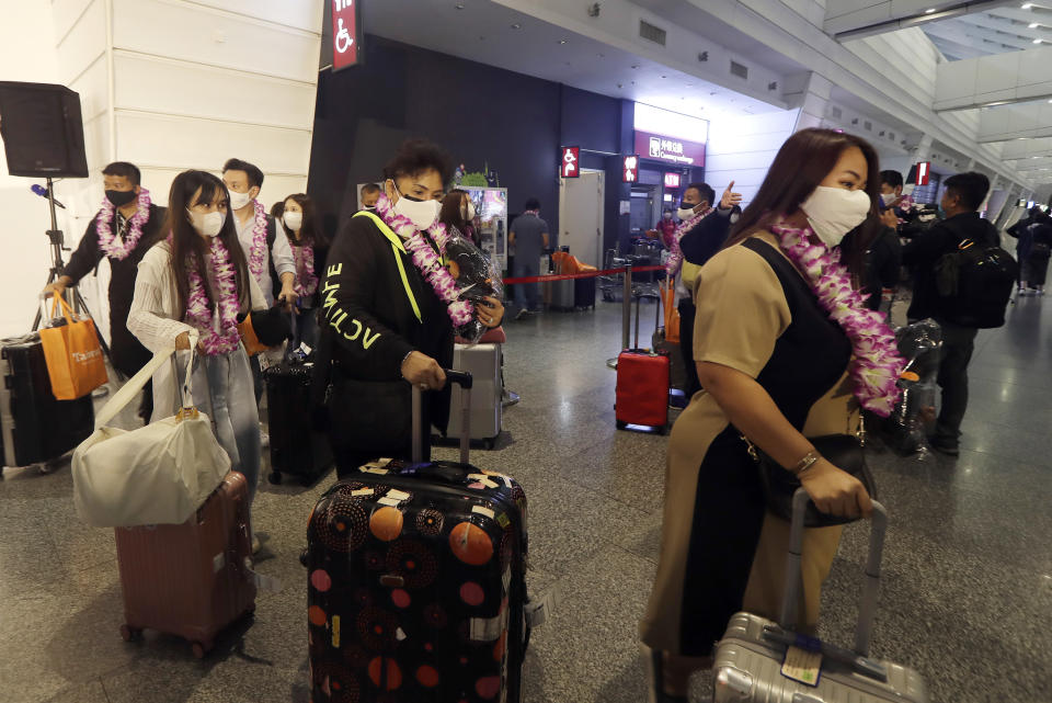 First group of foreign travelers arrive at Taoyuan International Airport in Taoyuan, Northern Taiwan, Thursday, Oct. 13, 2022. Taiwan announced that it will end mandatory COVID-19 quarantines for people arriving from overseas beginning Oct. 13. The Central Epidemic Command Center announced that the previous weeklong requirement will be replaced with a seven-day self-monitoring period. (AP Photo/Chiang Ying-ying)