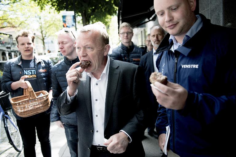 Danish opposition leader Lars Lokke Rasmussen (C) eats a meatball as he campaigns in the city of Lyngby on June 15, 2015