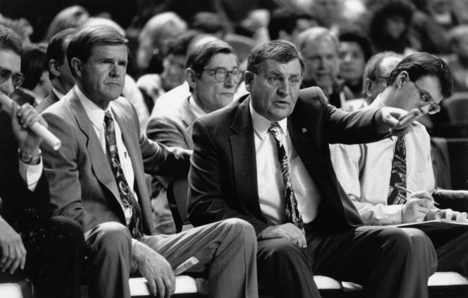 Louisville men's basketball assistant coach Jerry Jones, right, gestures toward the court during a U of L game with Hall of Fame head coach Denny Crum sitting next to him on the bench. Jones died Monday at age 89.