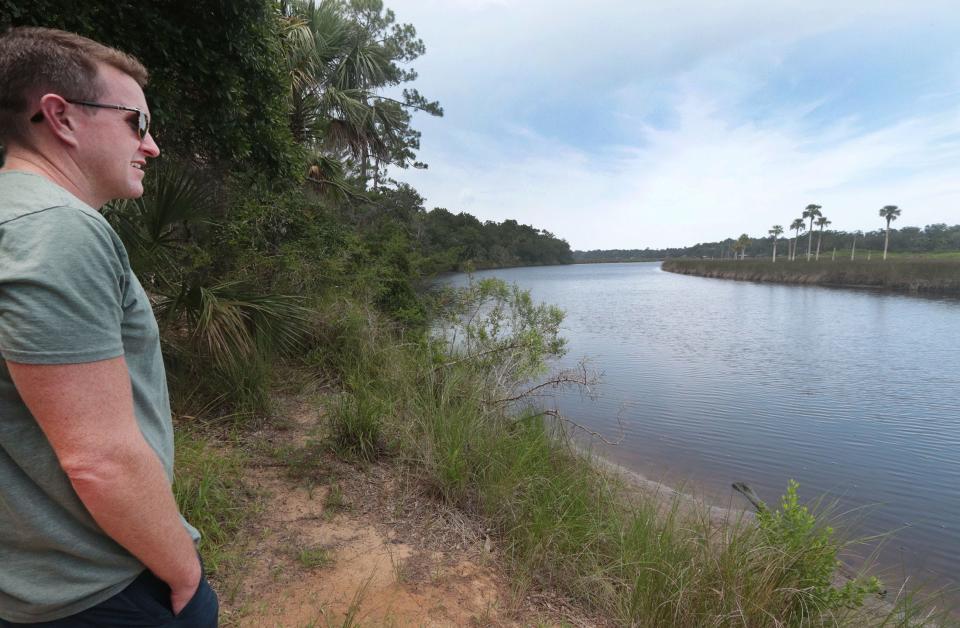 Bryon White, standing in the Doris Leeper preserve, overlooks Spruce Creek, designated an "Outstanding Florida Water" in 1991.