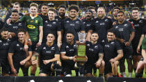 The All Blacks pose with the Freedom Cup after defeating the Springboks in their Rugby Championship test match in Townsville, Australia, Saturday, Sept. 25, 2021. (AP Photo/Tertius Pickard)