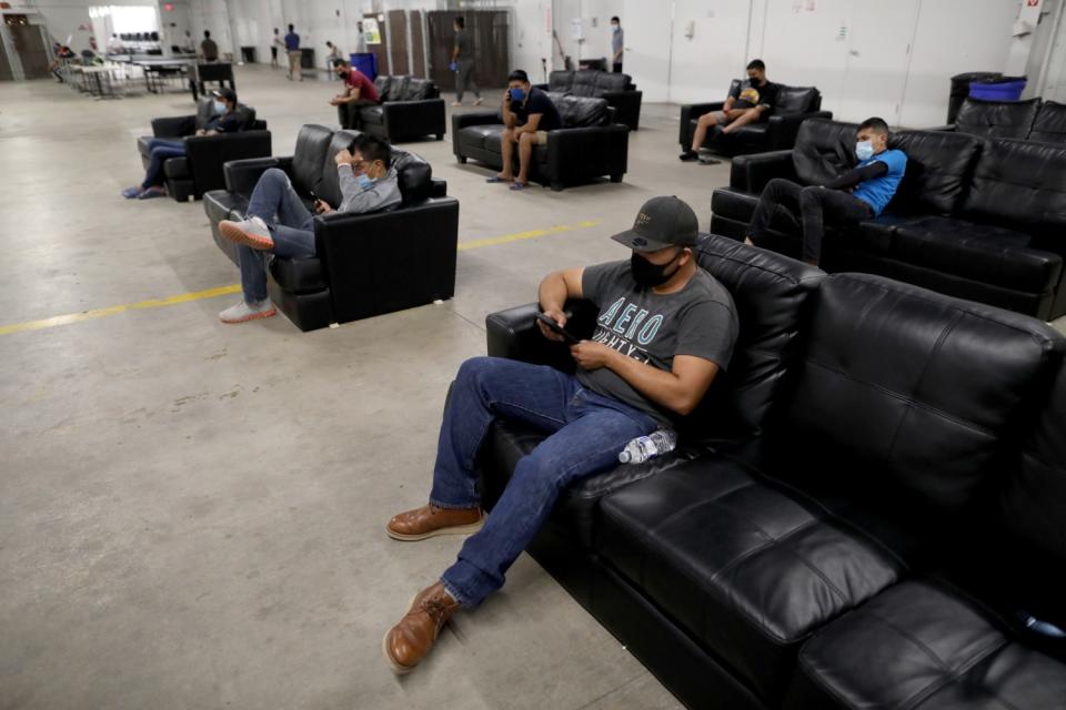 After finishing work, farmworkers relax in the living space practicing social distancing