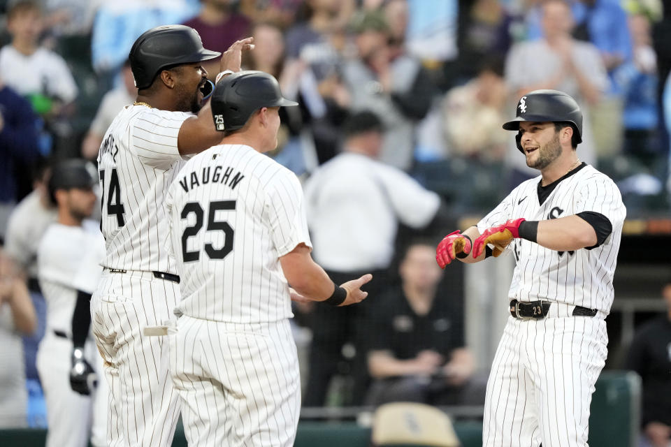 Chicago White Sox's Andrew Benintendi, right, is greeted at home plate by Eloy Jiménez, left, and Andrew Vaughn (25) after they scored on Benintendi's three-run home run off Tampa Bay Rays starting pitcher Aaron Civale during the fourth inning of a baseball game Saturday, April 27, 2024, in Chicago. (AP Photo/Charles Rex Arbogast)