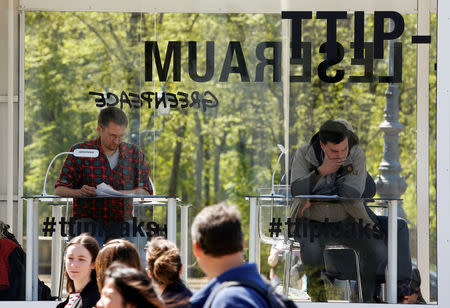 People read copies of the leaked TTIP negotiations inside a public reading room by the environmental campaign group Greenpeace in front of the Brandenburg Gate in Berlin, Germany, May 2, 2016. REUTERS/Fabrizio Bensch