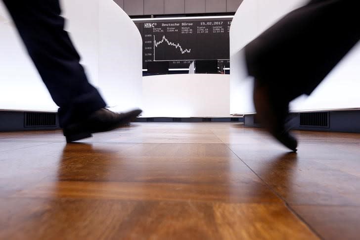 FILE PHOTO: A trader walks past the German DAX Index board on the trading floor at the Frankfurt stock exchange in Frankfurt, Germany February 15, 2017. REUTERS/Ralph Orlowski/File Photo