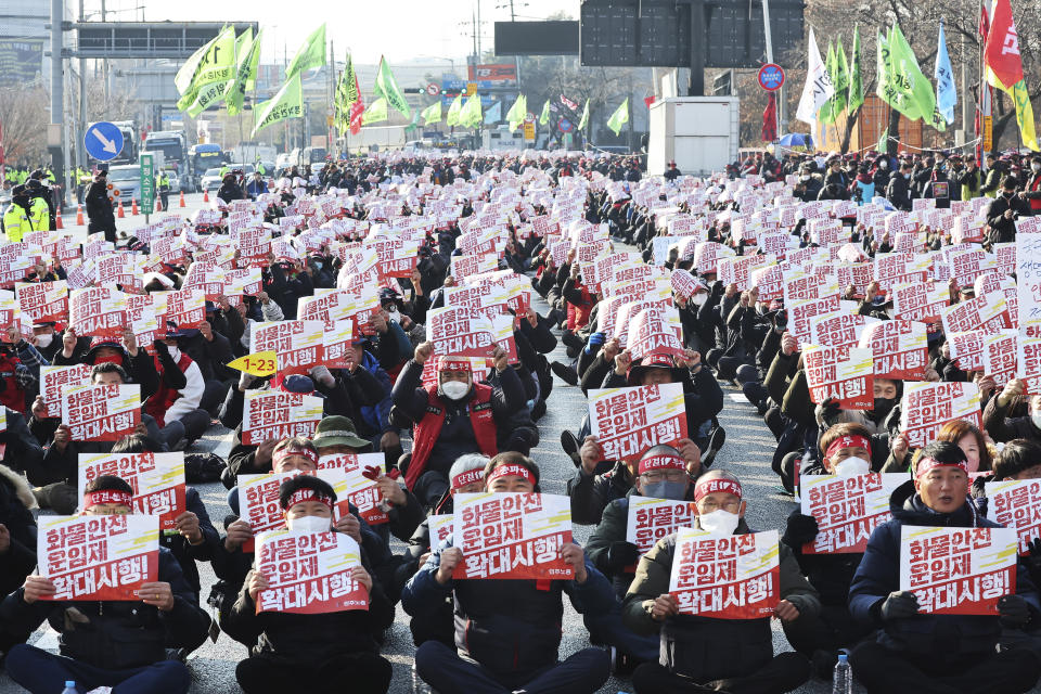 Members of the Korean Confederation of Trade Unions stage a rally to support the ongoing strike by truckers in Uiwang, South Korea, Tuesday, Dec. 6, 2022. The cards read "Expansion of safe trucking freight rates system." (Hong Gi-won/Yonhap via AP)