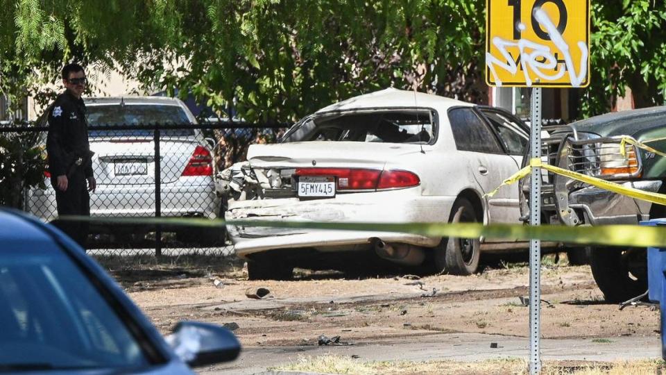 Fresno police investigate a scene at Chestnut and Lane avenues where a white vehicle, traveling at a high rate of speed, hit a garbage truck and then ended up in the yard of a residence on Thursday, Aug. 11, 2022. The driver of the white car was pronounced dead at the scene.