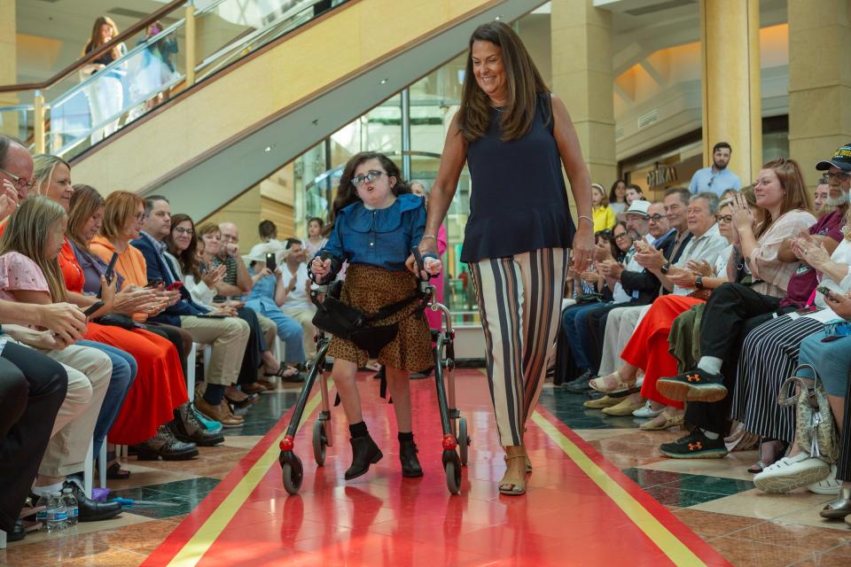 Faith Smith walks the runway alongside mentor Connie Beckett.