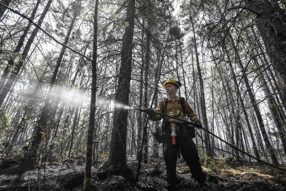 Department of Natural Resources and Renewables firefighter Kalen MacMullin of Sydney, Nova Scotia, works on a fire in Shelburne County, N.S. on Thursday, June 1, 2023. Rain and a rainy forecast for the weekend have fire officials hopeful they can get the largest wildfire ever recorded in Canada’s Atlantic Coast province of Nova Scotia under control. (Communications Nova Scotia /The Canadian Press via AP)