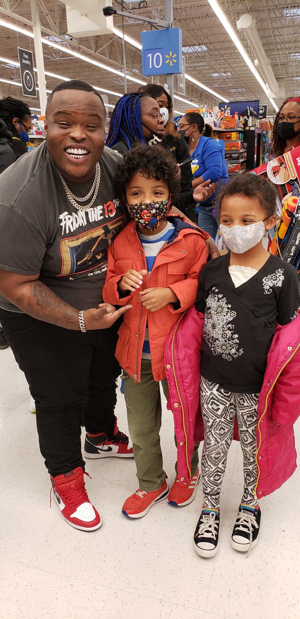 Hip-hop artist Morray poses for a photo with children at Walmart on Hope Mills on Tuesday afternoon, Dec. 21, 2021. The rapper was buying toys and other gifts to give out at a charity event he is co-sponsoring with barber Vic Blends. The Christmas Giveback is scheduled for Thursday in downtown Fayetteville.