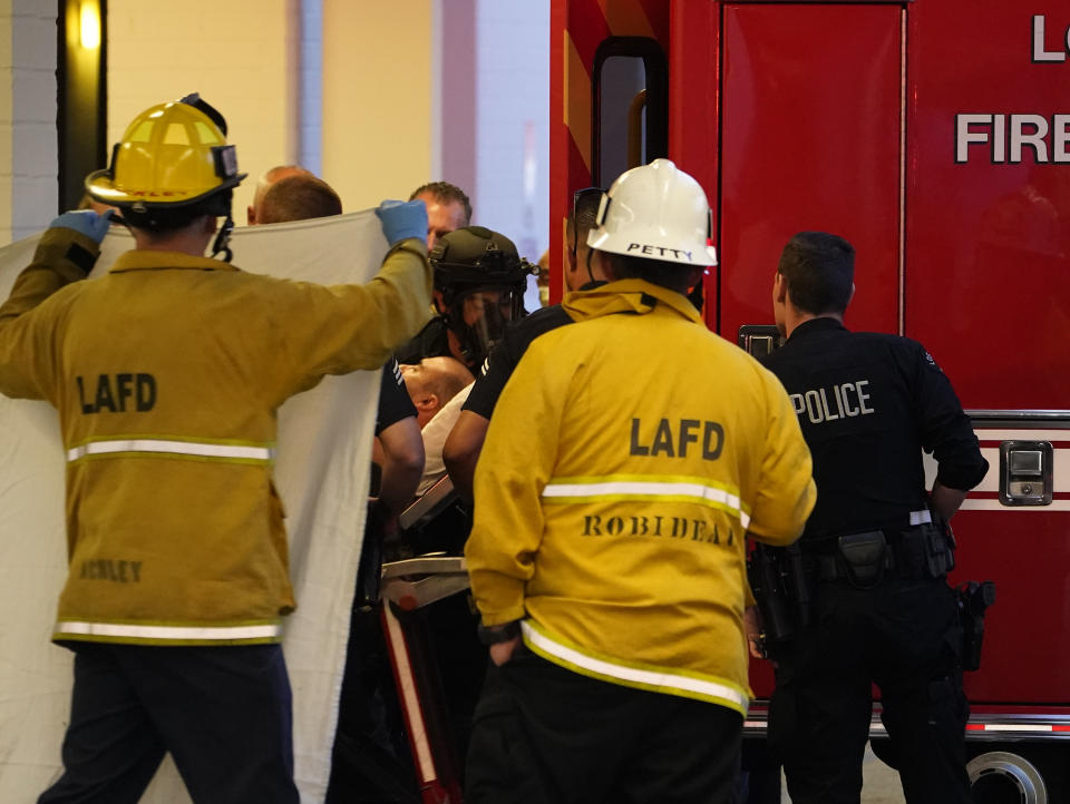 Un sospechoso que apuñaló a varias personas y se atrincheró en el interior de un hospital, es trasladado a una ambulancia tras ser sacado del centro médico, en Encino, California, el 3 de junio de 2022. (AP Foto/Damian Dovarganes)