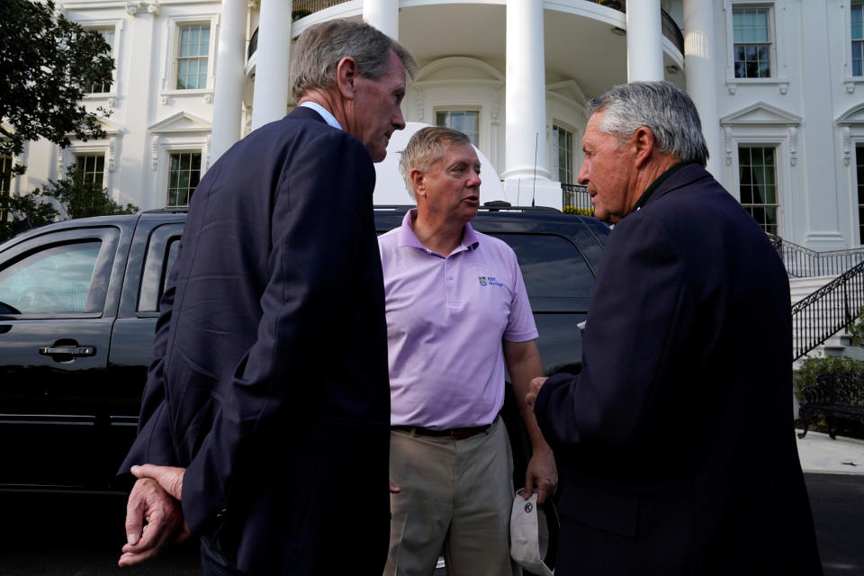 Sen. Lindsey Graham (center) and Gary Player return to the White House after a round of golf with the president. (Reuters)