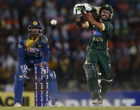 Pakistan's Fawad Alam (R) plays a shot next to Sri Lanka's wicketkeeper Kumar Sangakkara during their second ODI (One Day International) cricket match in Hambantota August 26, 2014. REUTERS/Dinuka Liyanawatte