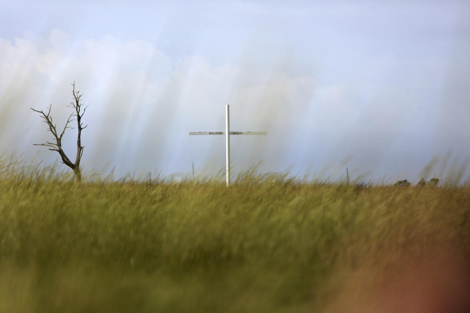 A cross marks one of several Pointe-au-Chien Indian Tribe burial grounds along Bayou Pointe-au-Chien in southern Louisiana on Wednesday, Sept. 29, 2021. The cemetery is one of many sacred grounds the local community is trying to save from coastal erosion and sea level rise. (AP Photo/Jessie Wardarski)