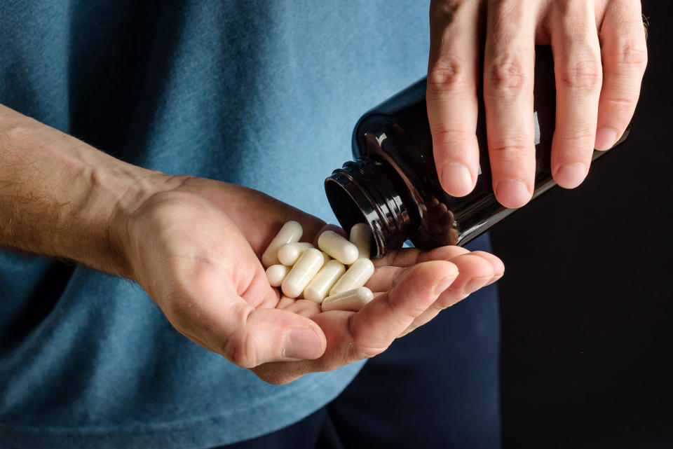 palm with capsules pill of sports supplements close-up.