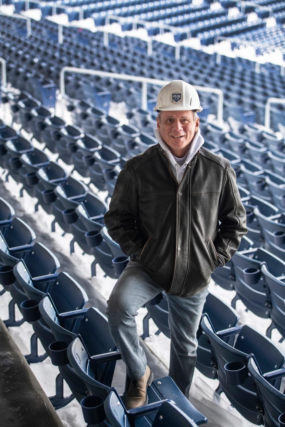 Larry Lucchino wears a Polar Park hard hat as he stands in the "Worcester Blue" seats.