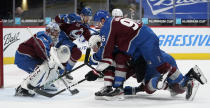 Arizona Coyotes center Christian Dvorak, bottom right, is knocked over while driving to the net by Colorado Avalanche right wing Mikko Rantanen, top right, as Avalanche goaltender Philipp Grubauer follows the puck in the second period of an NHL hockey game Monday, March 8, 2021, in downtown Denver. (AP Photo/David Zalubowski)