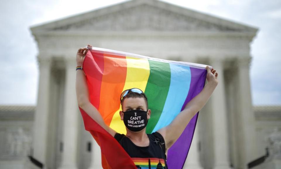 A demonstrator holds a Pride flag in front of the US supreme court building after the court ruled that LGBTQ people can not be disciplined or fired based on their sexual orientation.