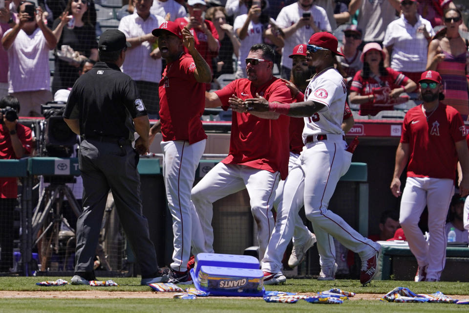 Los Angeles Angels' Raisel Iglesias, second from left, yells at first base umpire Rob Drake after a brawl broke out between members of the Angels and the Seattle Mariners during the second inning of a baseball game Sunday, June 26, 2022, in Anaheim, Calif. (AP Photo/Mark J. Terrill)