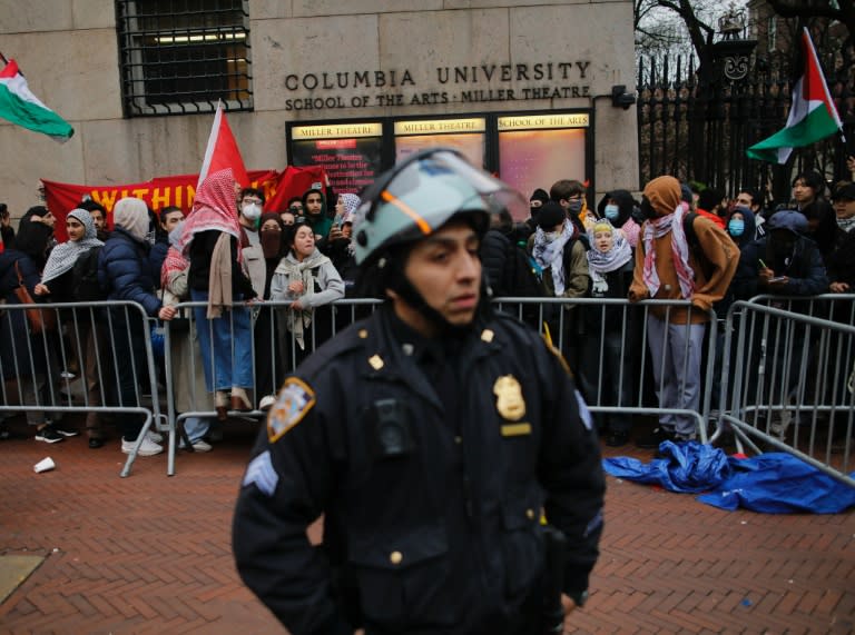 Manifestantes propalestinos detrás de un agente de policía a las afueras de la Universidad de Columbia, en Nueva York, el 18 de abril de 2024 (Kena Betancur)