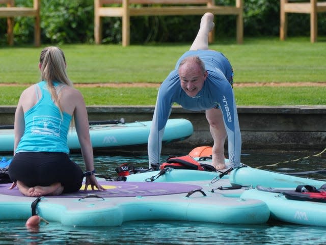 Sir Ed Davey tries his hand at a spot of paddleboard yoga during his visit to Streatley, Berkshire