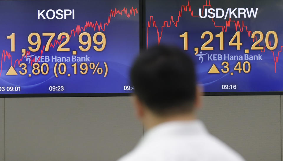 A currency trader walks by the screens showing the Korea Composite Stock Price Index (KOSPI), left, and the foreign exchange rate between U.S. dollar and South Korean won at the foreign exchange dealing room in Seoul, South Korea, Tuesday, Sept. 3, 2019. Asian stock markets were mostly lower Tuesday after investor jitters over U.S.-Chinese trade tension were revived by a report negotiators cannot agree on a schedule for talks this month. (AP Photo/Lee Jin-man)