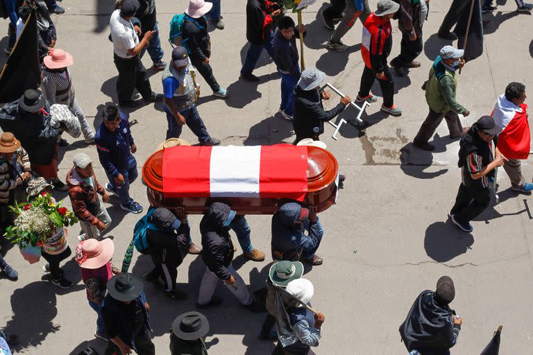 Familiares y amigos de las víctimas de los enfrentamientos con la policía peruana cargan sus féretros en la ciudad andina de Juliaca, en el sur de Perú, el 11 de enero de 2023. (Juan Carlos CISNEROS / AFP)