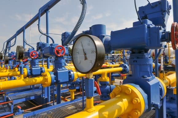 A pressure gauge, pipes, and valves at a natural gas treatment plant.