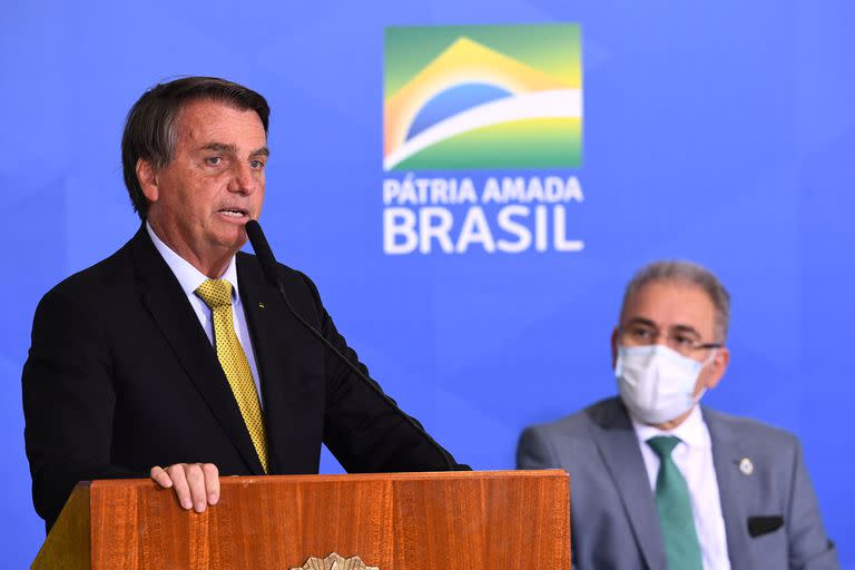 Jair Bolsonaro, en una conferencia de prensa con su ministro de Salud, Marcelo Queiroga (Photo by EVARISTO SA / AFP)