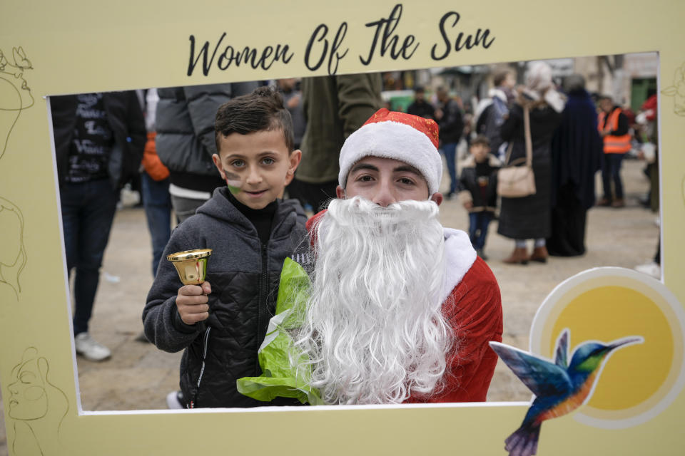 Children pose for a photo in Manger Square, adjacent to the Church of the Nativity, traditionally believed to be the birthplace of Jesus Christ, in the West Bank town of Bethlehem, Saturday, Dec. 24, 2022. (AP Photo/Majdi Mohammed)