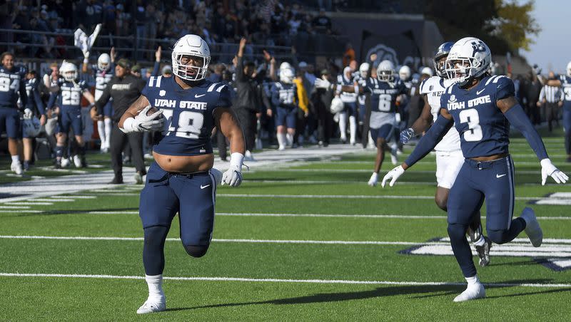 Utah State defensive tackle Seni Tuiaki (48) returns an interception for a touchdown against Nevada during the first half of an NCAA college football game Saturday, Nov. 11, 2023, in Logan, Utah. 