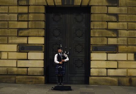 A musician, wearing a kilt, plays the bagpipes as he busks on the Royal Mile in Edinburgh, Scotland September 16, 2014. REUTERS/Dylan Martinez