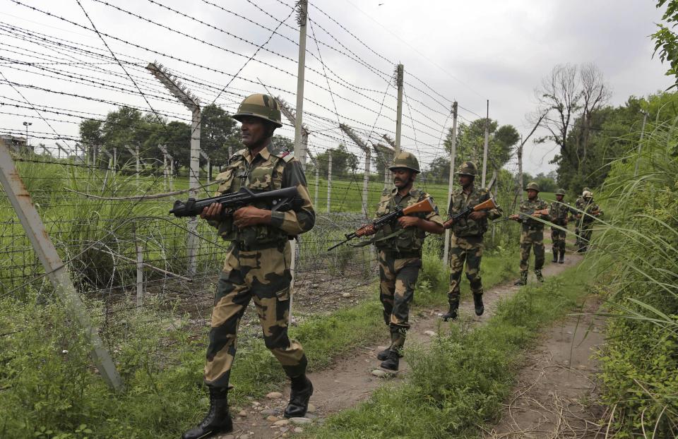 In this Tuesday, Aug. 13, 2019 file photo, India's Border Security Force (BSF) soldiers patrol near the India Pakistan border fencing at Garkhal in Akhnoor, about 35 kilometers (22 miles) west of Jammu, India. Pakistan's prime minister assured Kashmiri people living in the Indian-administered part of the divided region that he supports them in their struggle for self-determination. In his statement Wednesday, Imran Khan condemned New Delhi's decision Aug. 5 to downgrade Kashmir's status, as he began celebrations marking Pakistan's independence day.(AP Photo/Channi Anand)