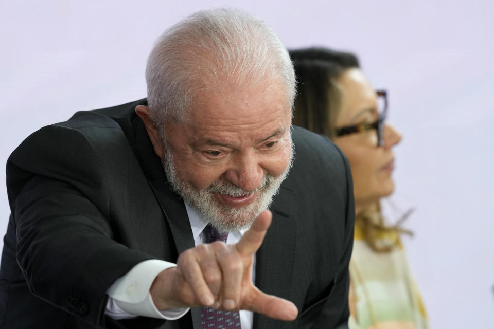 Brazil's President Luiz Inacio Lula da Silva flashes an "L" for Lula, during a ceremony relaunching the Bolsa Familia or Family Grant program, at the Planalto Palace, in Brasilia, Brazil, Thursday, March 2, 2023. Bolsa Familia is a cash transfer program that aims to help families living in poverty. (AP Photo/Eraldo Peres)