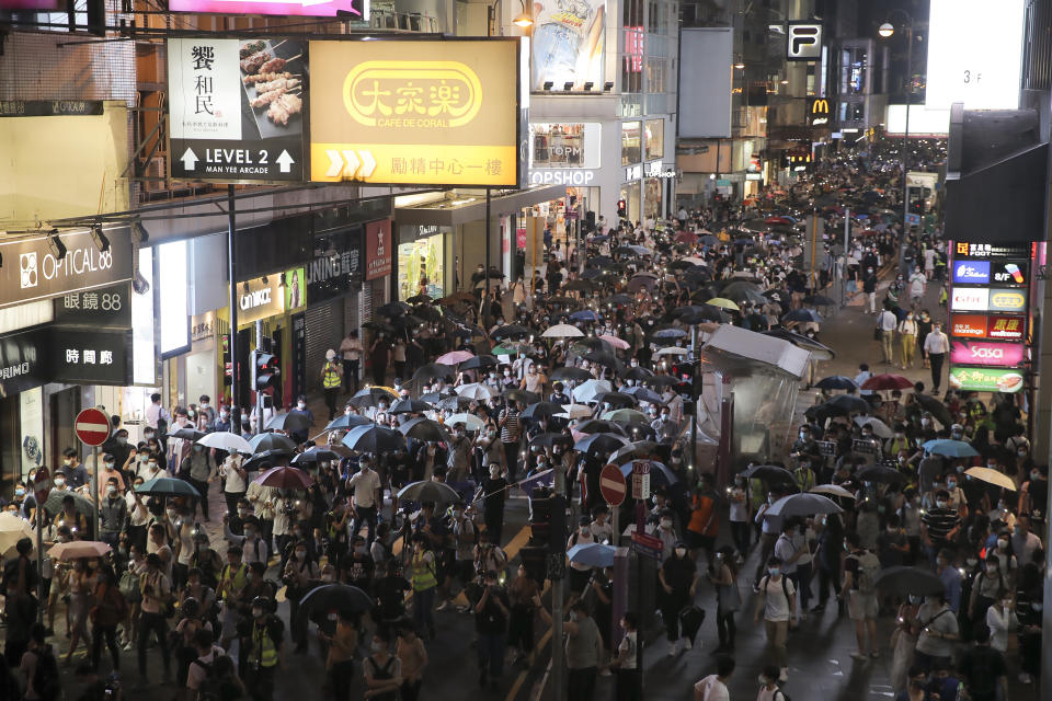 Pro-democracy demonstrators march holding their phones with flashlights on during a protest to mark the first anniversary of a mass rally against the now-withdrawn extradition bill in Hong Kong, Tuesday, June 9, 2020. One year ago, a sea of humanity a million people by some estimates marched through central Hong Kong on a steamy afternoon. It was the start of what would grow into the longest-lasting and most violent anti-government movement the city has seen since its return to China in 1997. (AP Photo/Kin Cheung)