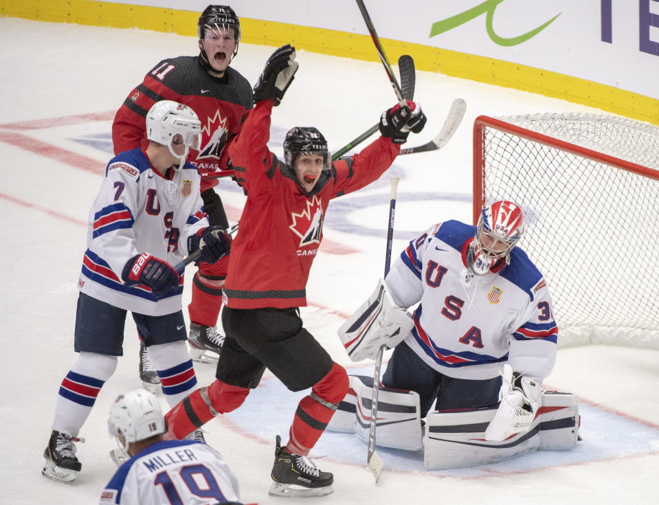 Canada's Dylan Cozens, centre, and teammate Alexis Lafreniere (11) react after the third goal on the United States goaltender Spencer Knight as teammates Spencer Stastney(7) and K'Andre Miller(19) look on during second period at the World Junior Hockey Championships in Ostrava, Czech Republic, Thursday, Dec. 26, 2019. (Ryan Remiorz/The Canadian Press via AP)