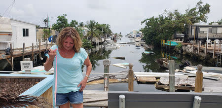 Terri Metter stands in front of what's left of destroyed trailers, that fill a canal near a trailer park in Marathon, Florida, U.S., June 10, 2018. REUTERS/Zach Fagenson