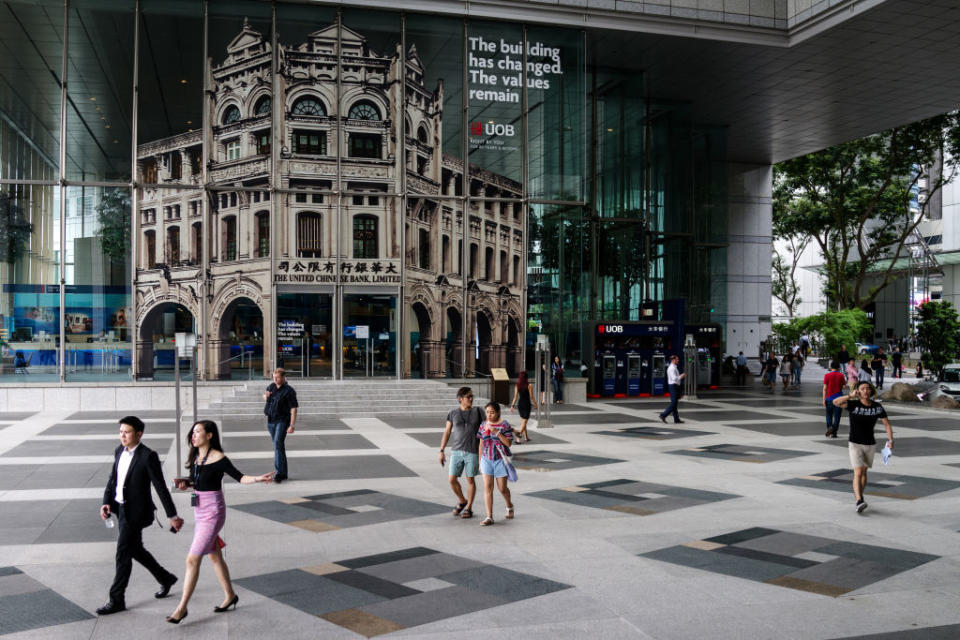 Pedestrians walk past an entrance to a United Overseas Bank Ltd. (UOB) branch in the central business district of Singapore, on Friday, June 2, 2017. (PHOTO: Sanjit Das/Bloomberg/Getty Images)